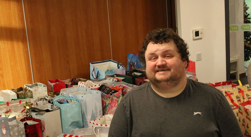 Ryan surrounded by shoeboxes that have been filled with donations.